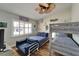 Cozy bedroom with a unique bunk bed setup, ceiling fan, wood-look floors, and natural light from a window at 743 Kingston Ct, Apollo Beach, FL 33572