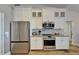 Modern kitchen boasting stainless steel appliances and white cabinetry with tiled backsplash at 743 Kingston Ct, Apollo Beach, FL 33572