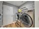 Modern laundry room featuring a front load washer and dryer with storage shelves at 743 Kingston Ct, Apollo Beach, FL 33572