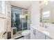 Modern bathroom featuring a glass shower, hexagon tile and a sleek, white vanity with brushed nickel hardware at 7763 Jenner Ave, New Port Richey, FL 34655