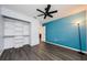 Well-lit bedroom with a blue accent wall, closet shelving and modern ceiling fan at 7763 Jenner Ave, New Port Richey, FL 34655
