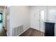 A bright foyer with white walls, wood-look floors, a white door, and a side table at 7763 Jenner Ave, New Port Richey, FL 34655