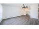 Bright living room featuring gray flooring, a modern ceiling fan, and seamless transition to dining area at 7763 Jenner Ave, New Port Richey, FL 34655