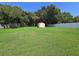 Expansive backyard features a well-maintained lawn, storage shed, and privacy fencing at 827 Creekside Ln, Palm Harbor, FL 34684