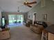 Inviting living room featuring plush furniture, a ceiling fan, and sliding glass doors to the backyard at 827 Creekside Ln, Palm Harbor, FL 34684