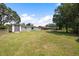 A spacious backyard offers ample green space, a storage shed, and serene outdoor relaxation possibilities at 916 Shangri La Dr, Seffner, FL 33584