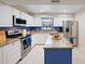Bright kitchen featuring white cabinets, stainless steel appliances, and a center island with granite countertops at 916 Shangri La Dr, Seffner, FL 33584