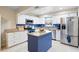 Modern kitchen with stainless steel appliances, white cabinets, and a blue island with granite countertops at 916 Shangri La Dr, Seffner, FL 33584