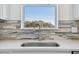Close-up of a kitchen sink with a stainless steel faucet, tiled backsplash, and a window offering a scenic view at 9474 Shorebird Ct, Parrish, FL 34219
