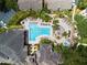Aerial view of a stylish community pool and lounge area with seating, spa, and lush landscaping at 10203 Courtney Palms Blvd # 301, Tampa, FL 33619