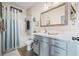 Well-lit bathroom features a tub with shower, and a modern vanity with a large mirror at 10203 Courtney Palms Blvd # 301, Tampa, FL 33619