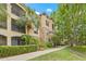 Exterior elevation of a multi-story residential building with balconies and manicured landscaping at 10203 Courtney Palms Blvd # 301, Tampa, FL 33619