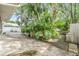 Private backyard oasis with lush tropical landscaping, concrete patio, and wooden walkway at 1041 Forest Grove Blvd, Palm Harbor, FL 34683