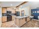 Modern kitchen features stainless steel appliances, light wood cabinets, granite countertops, and breakfast bar at 1041 Forest Grove Blvd, Palm Harbor, FL 34683