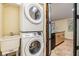 Efficient laundry area with stacked washer/dryer and utility sink, adjacent to bright kitchen with modern finishes at 1041 Forest Grove Blvd, Palm Harbor, FL 34683