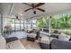 Relaxing screened-in patio with ceiling fans, comfortable seating, and views of the lush backyard at 1041 Forest Grove Blvd, Palm Harbor, FL 34683