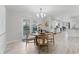 Elegant dining area with modern chandelier, light wood flooring, and seamless outdoor access at 10710 Donbrese Ave, Tampa, FL 33615