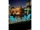 Inviting waterfront dock scene with Adirondack chairs and small tables perfect for relaxing by the serene, moonlit water at 10710 Donbrese Ave, Tampa, FL 33615