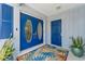 Home double door entrance with blue doors, patterned rug, and accent plants at 10710 Donbrese Ave, Tampa, FL 33615