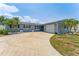 Charming home exterior with blue siding, landscaped yard, palm trees, and driveway at 10710 Donbrese Ave, Tampa, FL 33615