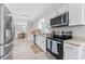 Modern kitchen with stainless steel appliances and sleek white cabinetry at 10710 Donbrese Ave, Tampa, FL 33615