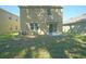 Backyard with large grassy area, concrete patio, and view of the rear of the house with sliding glass door at 10928 Carlton Fields Dr, Riverview, FL 33579