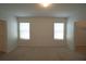 Spacious bedroom with two windows, neutral carpet and walk-in closet at 10928 Carlton Fields Dr, Riverview, FL 33579