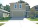 Two-story home with a beige exterior, two-car garage, and a spacious driveway at 10928 Carlton Fields Dr, Riverview, FL 33579