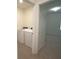 Convenient laundry room with tile floor, washer and dryer, located next to bedroom with carpet at 10928 Carlton Fields Dr, Riverview, FL 33579