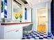 Bright bathroom with double sinks, vanity seating, and blue and white checkerboard flooring at 1111 Briarwood Rd, Brandon, FL 33511