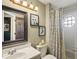 Charming bathroom features a single vanity, decorative mirror, and shower/tub combo with a patterned shower curtain at 11849 Cedarfield Dr, Riverview, FL 33579