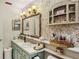 Bathroom featuring double sinks, a large framed mirror, and a unique wallpaper design at 11849 Cedarfield Dr, Riverview, FL 33579