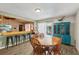 Bright dining area featuring wood-look tile flooring, a bar, and seating for six at 11849 Cedarfield Dr, Riverview, FL 33579
