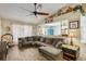 Comfortable living room featuring wood-look tile flooring, a ceiling fan, and a sectional couch at 11849 Cedarfield Dr, Riverview, FL 33579