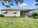 View of the backyard from the side of the house with a screen patio, awning and green grass at 12125 71St Way, Largo, FL 33773