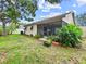 View of the backyard from the side of the house with a screen patio and awning at 12125 71St Way, Largo, FL 33773