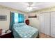 Charming bedroom with a ceiling fan, wood flooring, a decorative border and a single bed with blue cover at 12125 71St Way, Largo, FL 33773