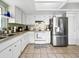 Bright kitchen features white cabinets and stainless steel refrigerator at 12125 71St Way, Largo, FL 33773