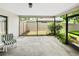 Screened patio area with concrete flooring, view of the fenced backyard and some patio seating at 12125 71St Way, Largo, FL 33773