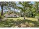 Large backyard with mature trees and a chain-link fence provides ample space for outdoor activities and is perfect for pets at 1221 Candlelight Blvd, Brooksville, FL 34601