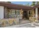 Inviting entryway with stone accents, dark brown door, and covered porch area at 1221 Candlelight Blvd, Brooksville, FL 34601