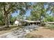 Charming ranch-style home with a two-car garage and a long driveway, surrounded by mature shade trees at 1221 Candlelight Blvd, Brooksville, FL 34601
