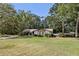 Charming ranch-style home featuring a stone facade, a lush, green front lawn, and mature shade trees at 1221 Candlelight Blvd, Brooksville, FL 34601