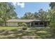 Exterior backyard view, with manicured lawn, trees and an enclosed patio, enhancing the property's appeal at 1221 Candlelight Blvd, Brooksville, FL 34601
