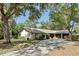 Charming ranch-style home with a two-car garage and a long driveway, surrounded by mature shade trees at 1221 Candlelight Blvd, Brooksville, FL 34601