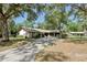 Charming ranch-style home with a two-car garage and a long driveway, surrounded by mature shade trees at 1221 Candlelight Blvd, Brooksville, FL 34601