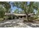 Charming ranch-style home with a two-car garage and a long driveway, surrounded by mature shade trees at 1221 Candlelight Blvd, Brooksville, FL 34601