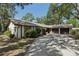Charming ranch-style home with a two-car garage and a long driveway, surrounded by mature shade trees at 1221 Candlelight Blvd, Brooksville, FL 34601