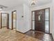 Bright foyer featuring a decorative wooden door, tile flooring, and access to other rooms at 1221 Candlelight Blvd, Brooksville, FL 34601