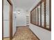 Hallway with white walls and tile floors, a decorative wood partition, and access to the kitchen and living areas at 1221 Candlelight Blvd, Brooksville, FL 34601